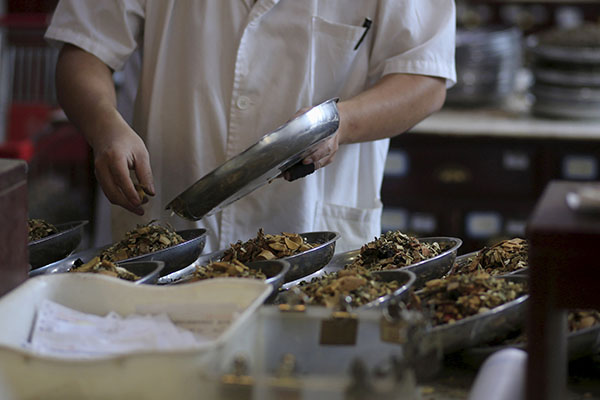 An employee works at a traditional Chinese medicine shop in Shanghai